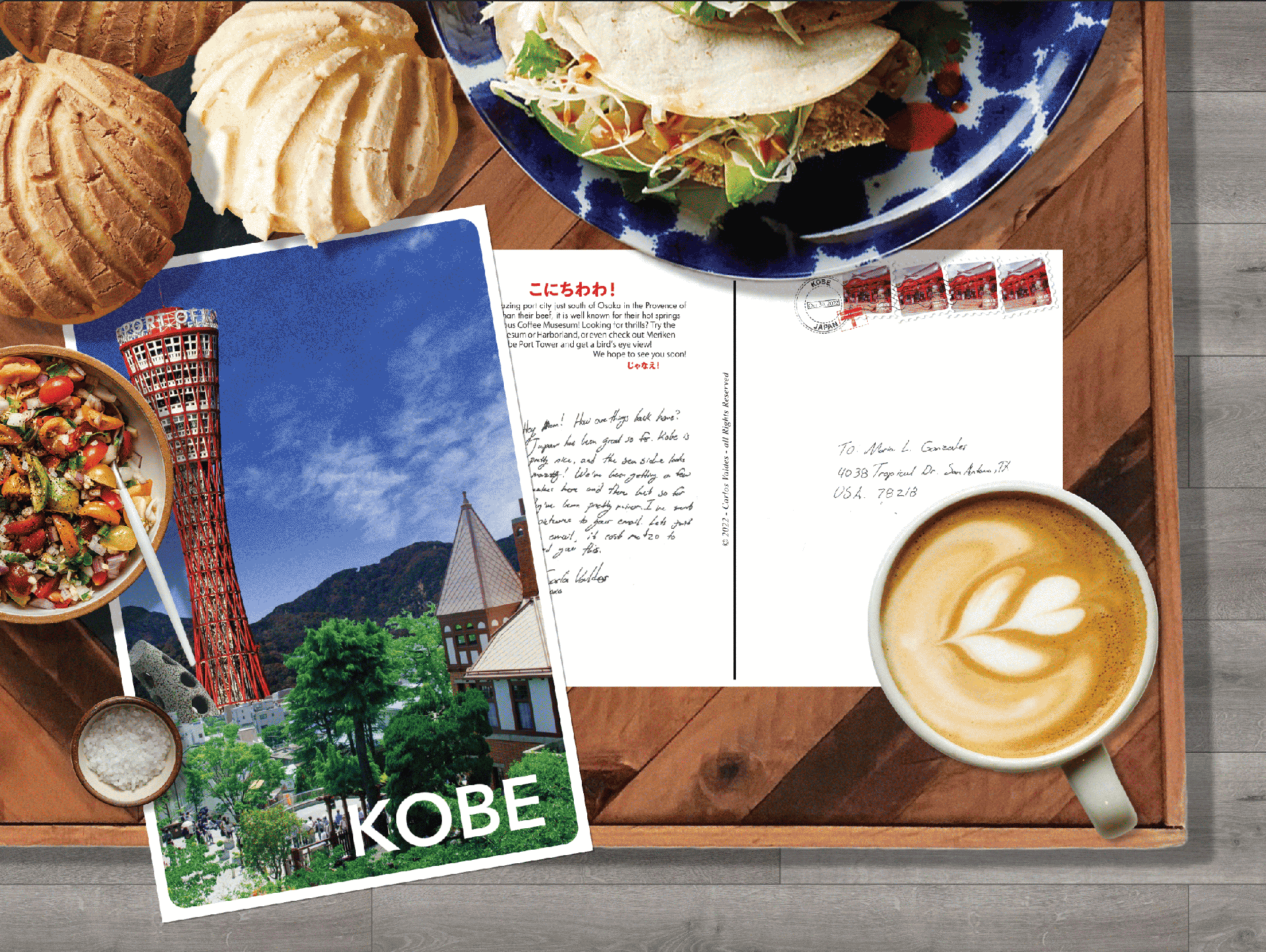 Post card from Kobe Japan on a coffee table filled with pan dulce, taccos, and spices.