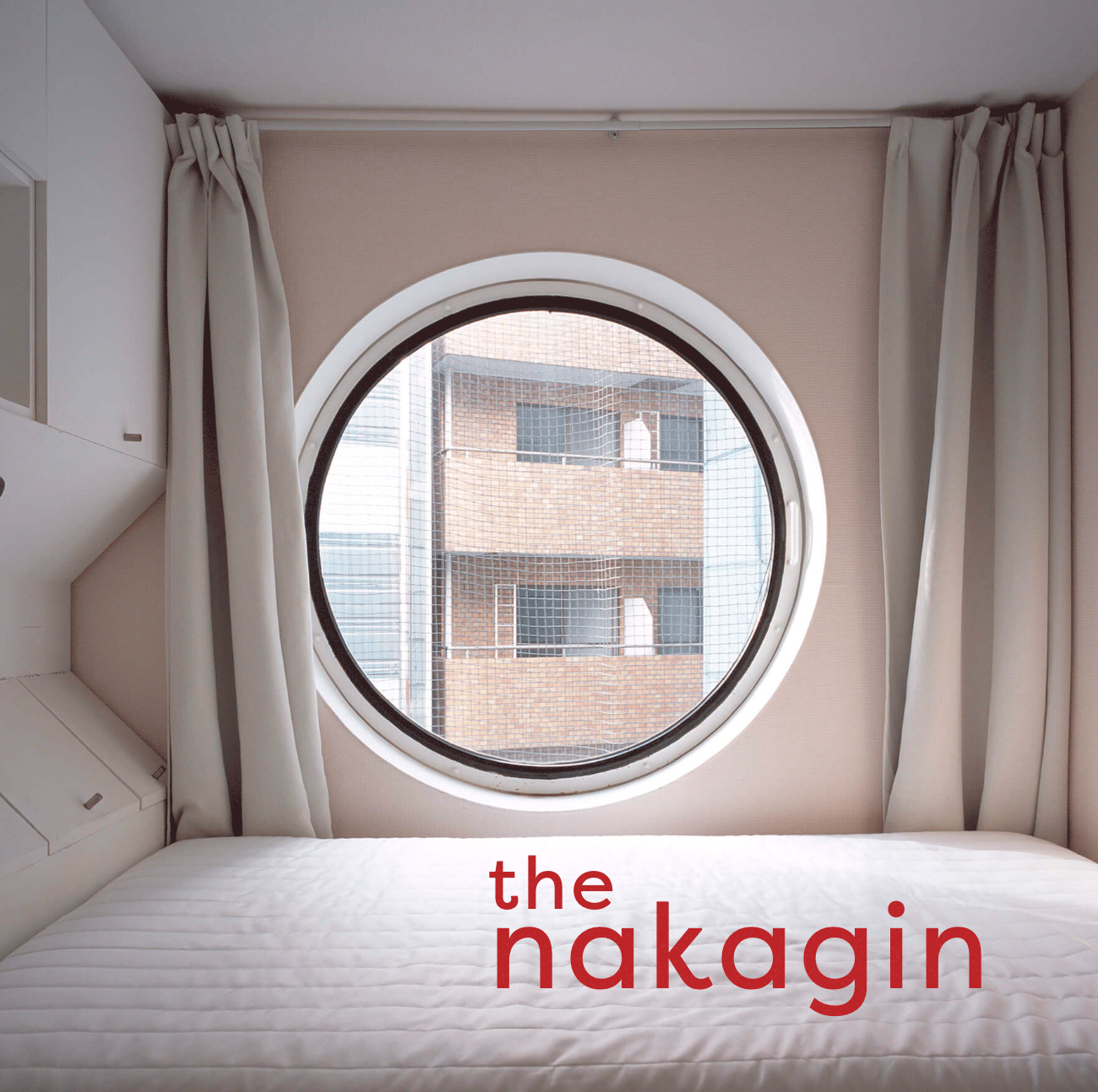 small room with a desk and bed with a large cucular window in the middle